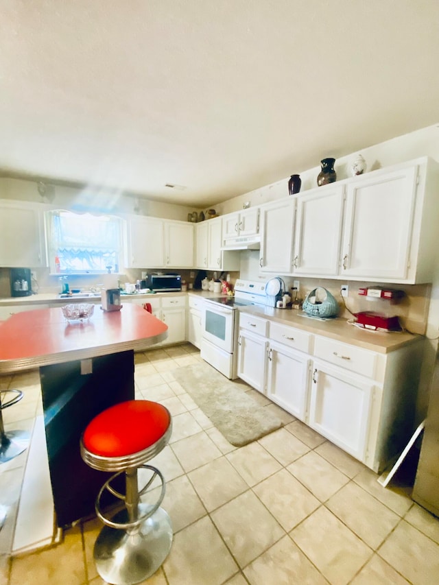 kitchen with white cabinetry, light tile patterned flooring, and white range with electric stovetop