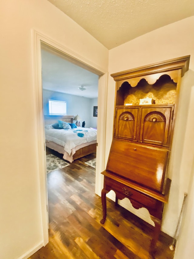 hall featuring a textured ceiling and wood finished floors