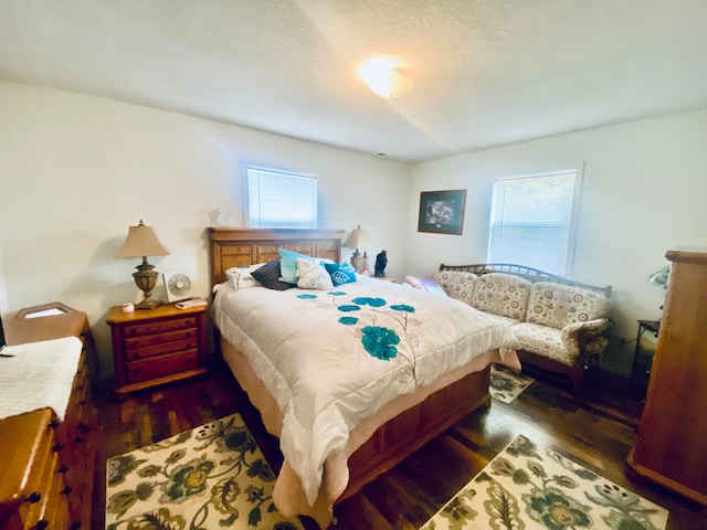 bedroom with multiple windows and dark hardwood / wood-style floors