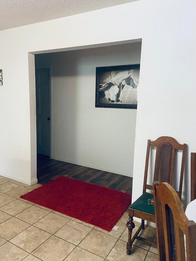 hallway featuring tile patterned floors and a textured ceiling