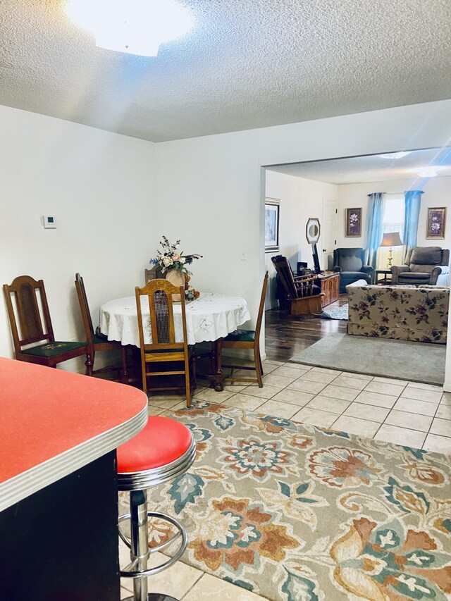 dining area featuring tile patterned floors and a textured ceiling
