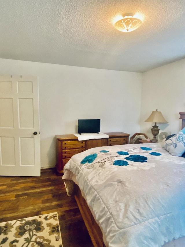 bedroom with dark wood-type flooring and a textured ceiling