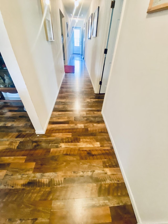 hallway with baseboards and hardwood / wood-style flooring
