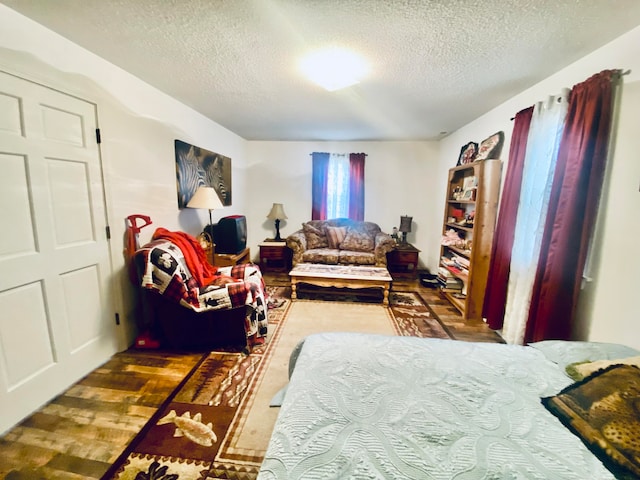 bedroom with a textured ceiling and dark hardwood / wood-style flooring