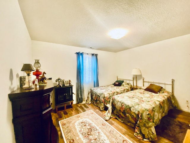 bedroom with hardwood / wood-style flooring and a textured ceiling