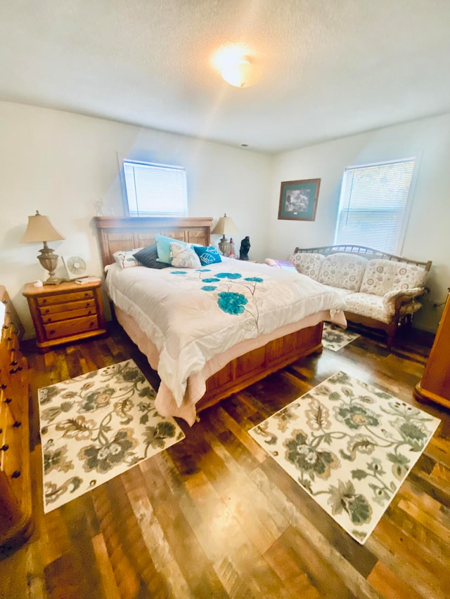 bedroom with a textured ceiling and dark hardwood / wood-style flooring