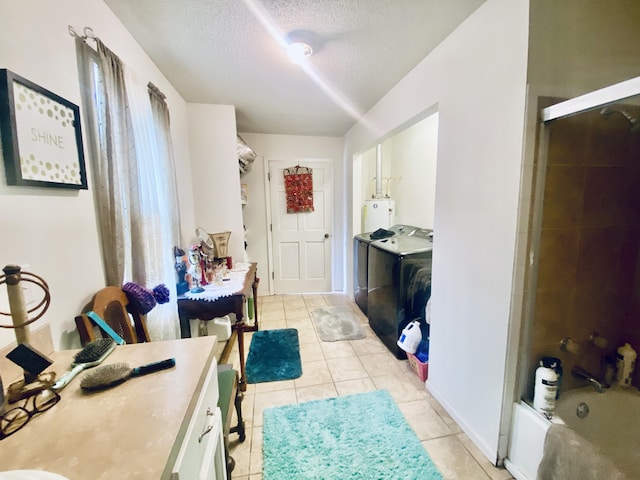 interior space featuring a textured ceiling, vanity, tile patterned floors, water heater, and washer and dryer