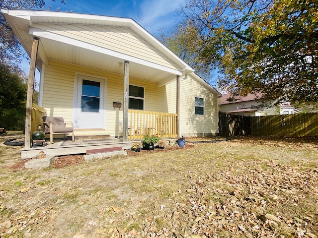exterior space featuring a porch and fence