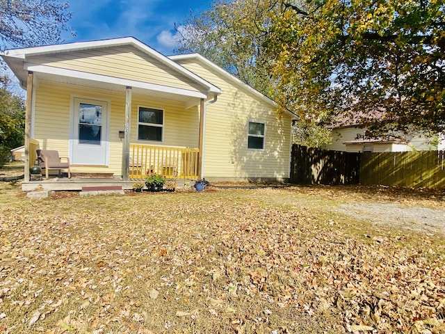 view of front of property featuring fence and a porch