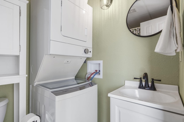 laundry room featuring sink and stacked washer and clothes dryer