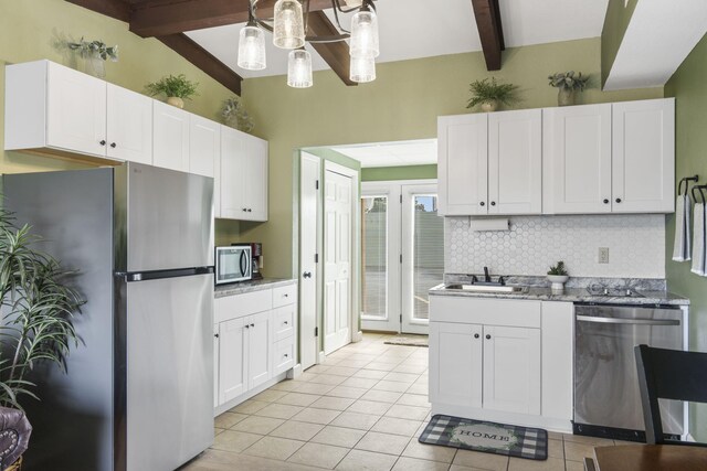 kitchen featuring appliances with stainless steel finishes, tasteful backsplash, decorative light fixtures, light tile patterned flooring, and white cabinetry