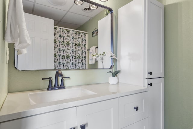 bathroom featuring vanity and a drop ceiling