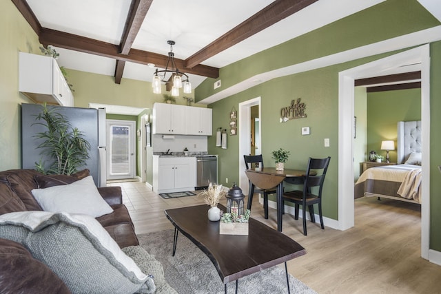 living room featuring beamed ceiling, light hardwood / wood-style flooring, a notable chandelier, and sink