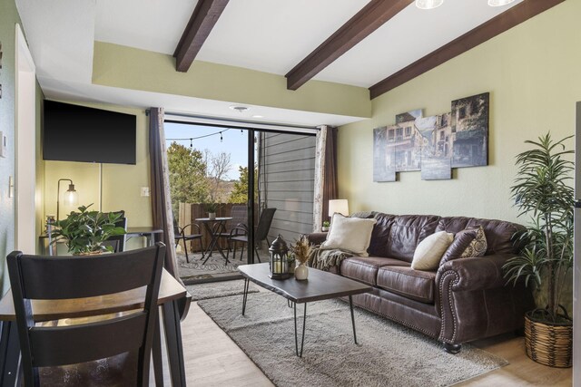 living room with beamed ceiling and light wood-type flooring