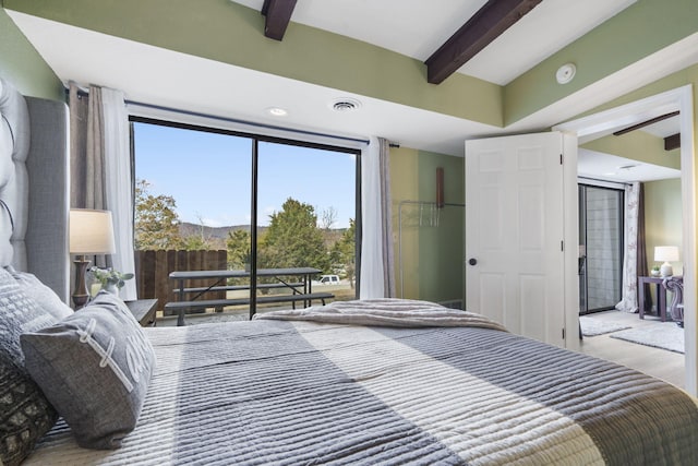 bedroom featuring beam ceiling and hardwood / wood-style flooring