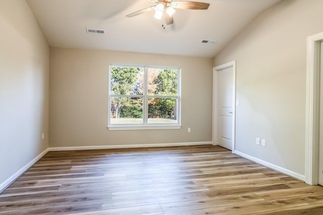 spare room featuring light hardwood / wood-style floors, lofted ceiling, and ceiling fan