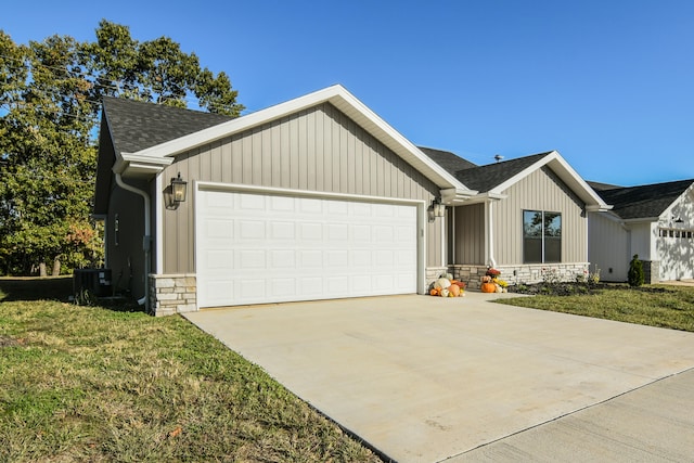 ranch-style house with central air condition unit, a front yard, and a garage