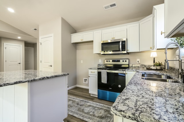 kitchen featuring white cabinetry, stainless steel appliances, and lofted ceiling