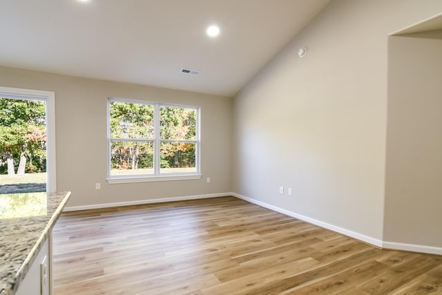 interior space featuring lofted ceiling and light hardwood / wood-style floors