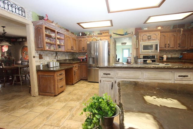 1819 Pleasant Hill Rd, Seymour, MO 65746 - kitchen with stainless steel appliances, tasteful backsplash, dark stone counters, and brown cabinets