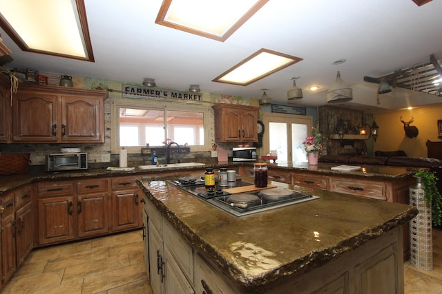 1819 Pleasant Hill Rd, Seymour, MO 65746 - kitchen featuring black electric cooktop, a sink, a kitchen island, stainless steel microwave, and dark stone counters