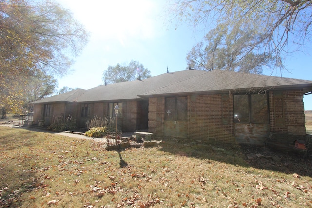 rear view of property featuring a lawn