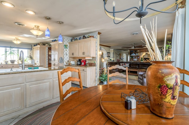 dining room featuring ornamental molding, sink, and ceiling fan with notable chandelier