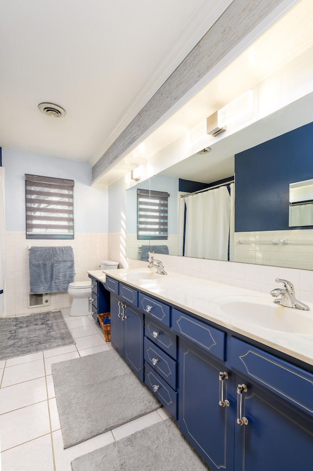 bathroom featuring toilet, tile patterned flooring, vanity, curtained shower, and tile walls