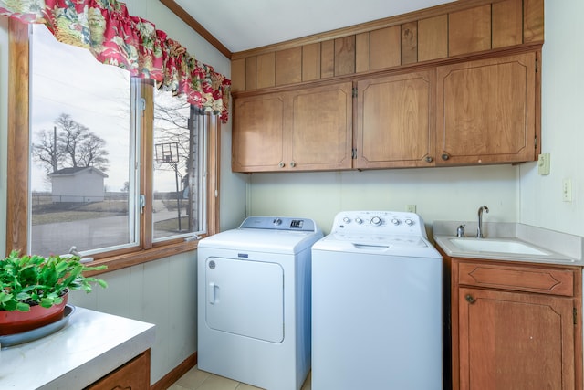 laundry room with cabinets, crown molding, sink, and washing machine and dryer