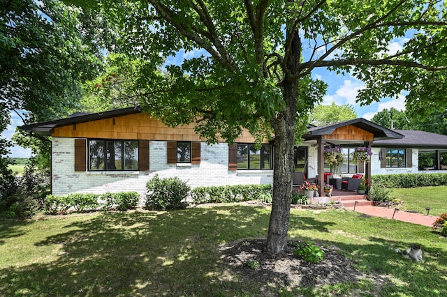 ranch-style home with covered porch and a front yard