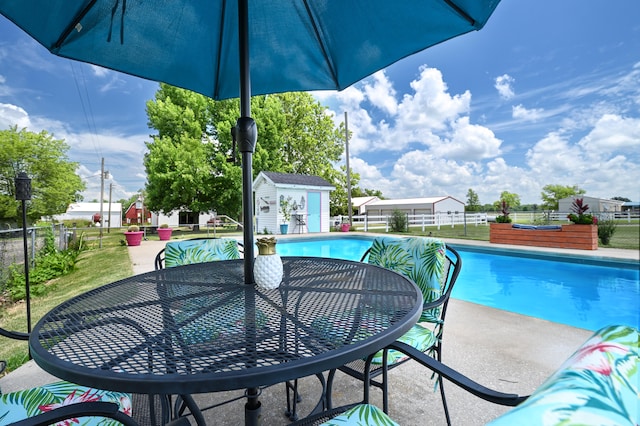 view of swimming pool with a patio area and an outbuilding