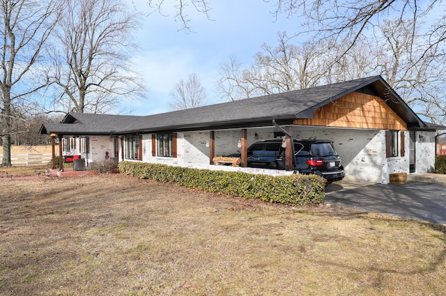 view of front facade featuring brick siding, aphalt driveway, and a carport