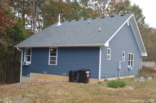 back of property with cooling unit and a lawn