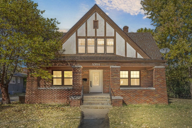 tudor house featuring covered porch