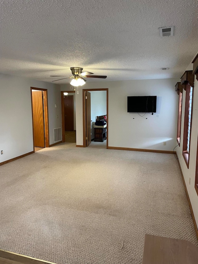 spare room featuring ceiling fan, carpet, and a textured ceiling