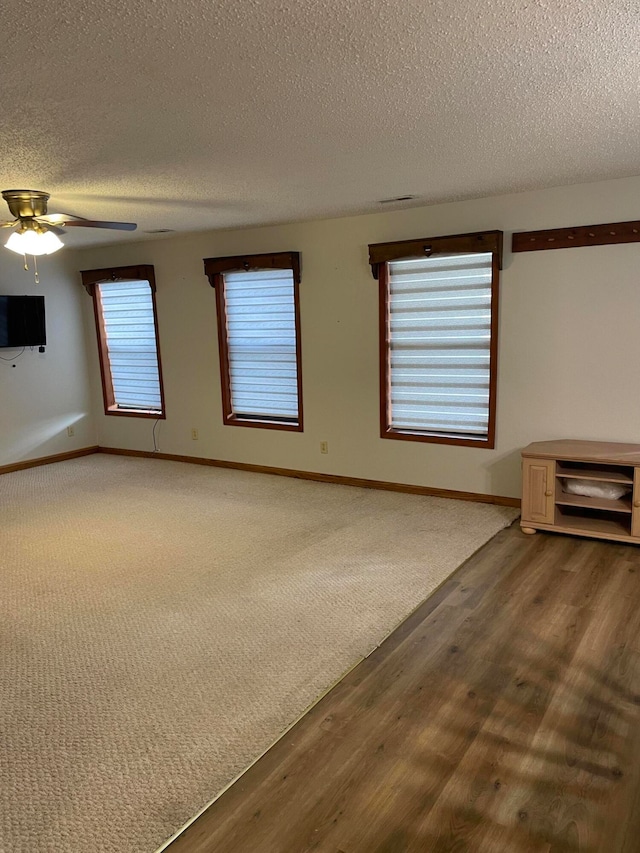 unfurnished room featuring ceiling fan, wood-type flooring, and a textured ceiling