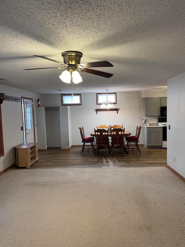 dining area with plenty of natural light, ceiling fan, a textured ceiling, and dark carpet