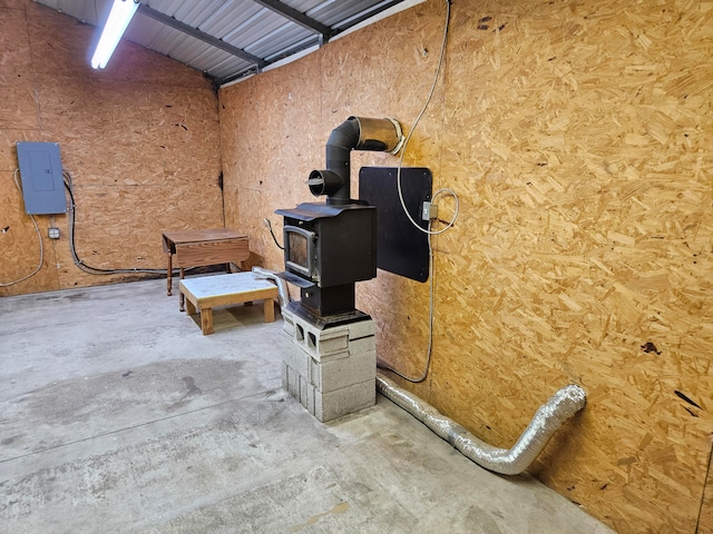 garage featuring electric panel and a wood stove