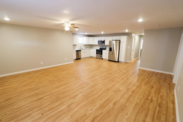 unfurnished living room featuring sink, ceiling fan, and light hardwood / wood-style flooring