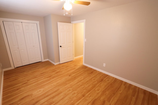 unfurnished bedroom with light hardwood / wood-style flooring, a closet, and ceiling fan