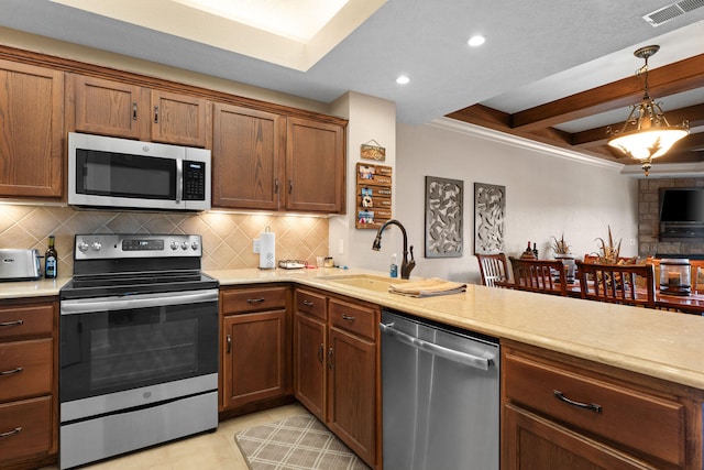 kitchen with appliances with stainless steel finishes, sink, beamed ceiling, pendant lighting, and decorative backsplash