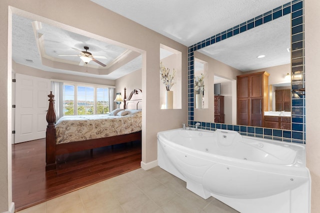 250 Lakewood Dr Unit 6303, Hollister, MO 65672 - ensuite bathroom with a textured ceiling, a jetted tub, a ceiling fan, wood finished floors, and baseboards