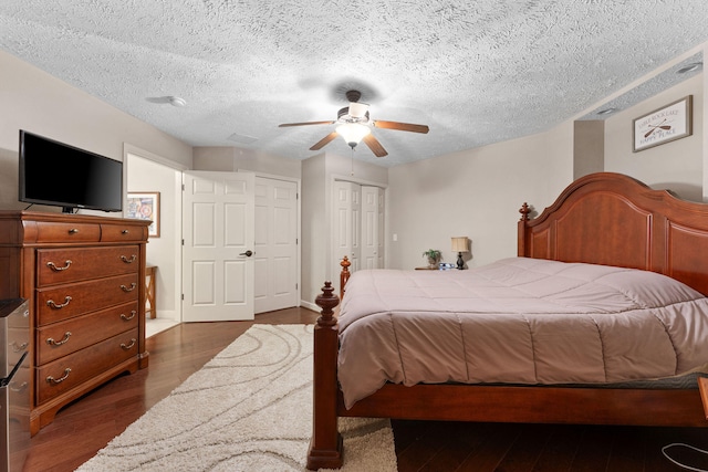 bedroom featuring ceiling fan, a textured ceiling, and dark hardwood / wood-style floors