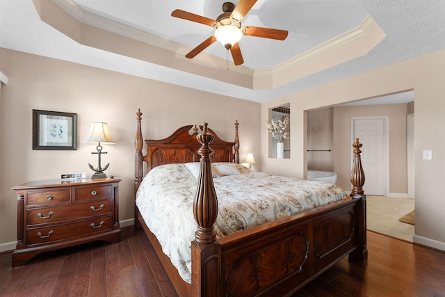 bedroom featuring dark wood-type flooring, a tray ceiling, crown molding, a textured ceiling, and ceiling fan