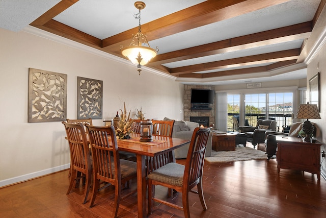 dining space with a stone fireplace, dark hardwood / wood-style floors, a tray ceiling, and ornamental molding