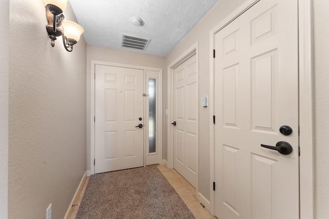 entryway featuring a textured ceiling and light tile patterned floors