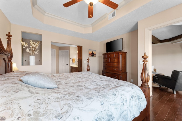 bedroom with dark hardwood / wood-style flooring, a textured ceiling, a tray ceiling, and ceiling fan