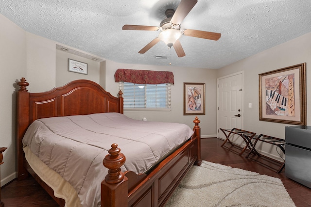 bedroom featuring dark hardwood / wood-style floors, a textured ceiling, and ceiling fan