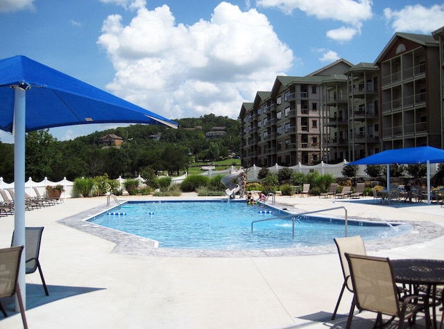 view of swimming pool featuring a water slide and a patio area