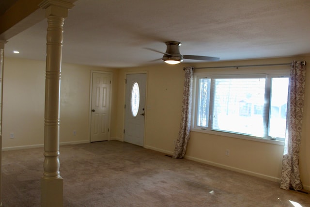 entrance foyer with ornate columns, light carpet, and ceiling fan